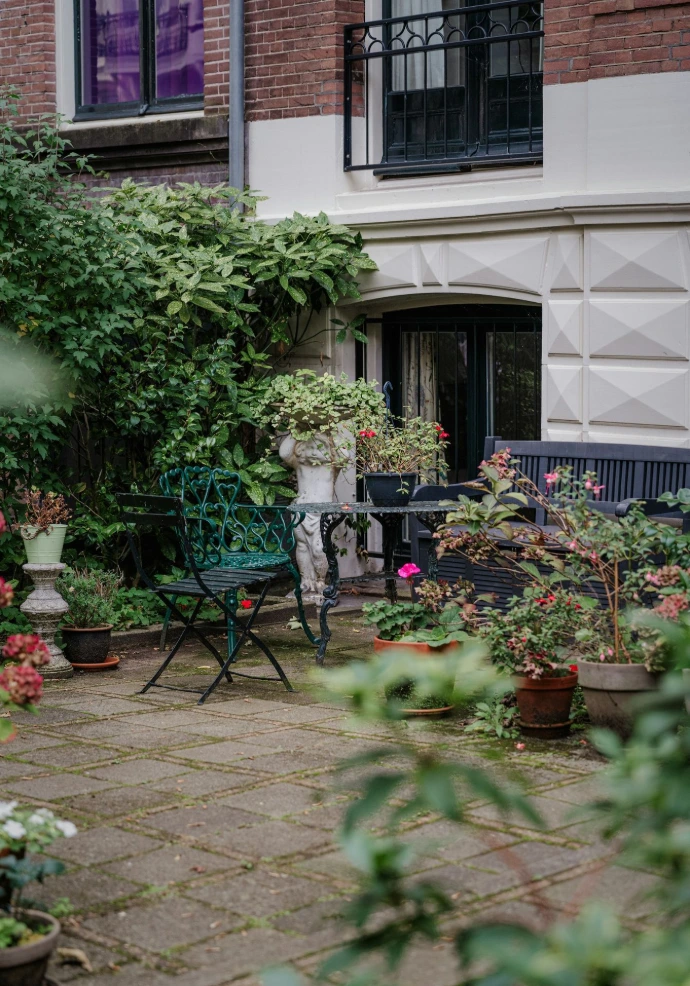 A quaint garden patio with potted plants and seating.